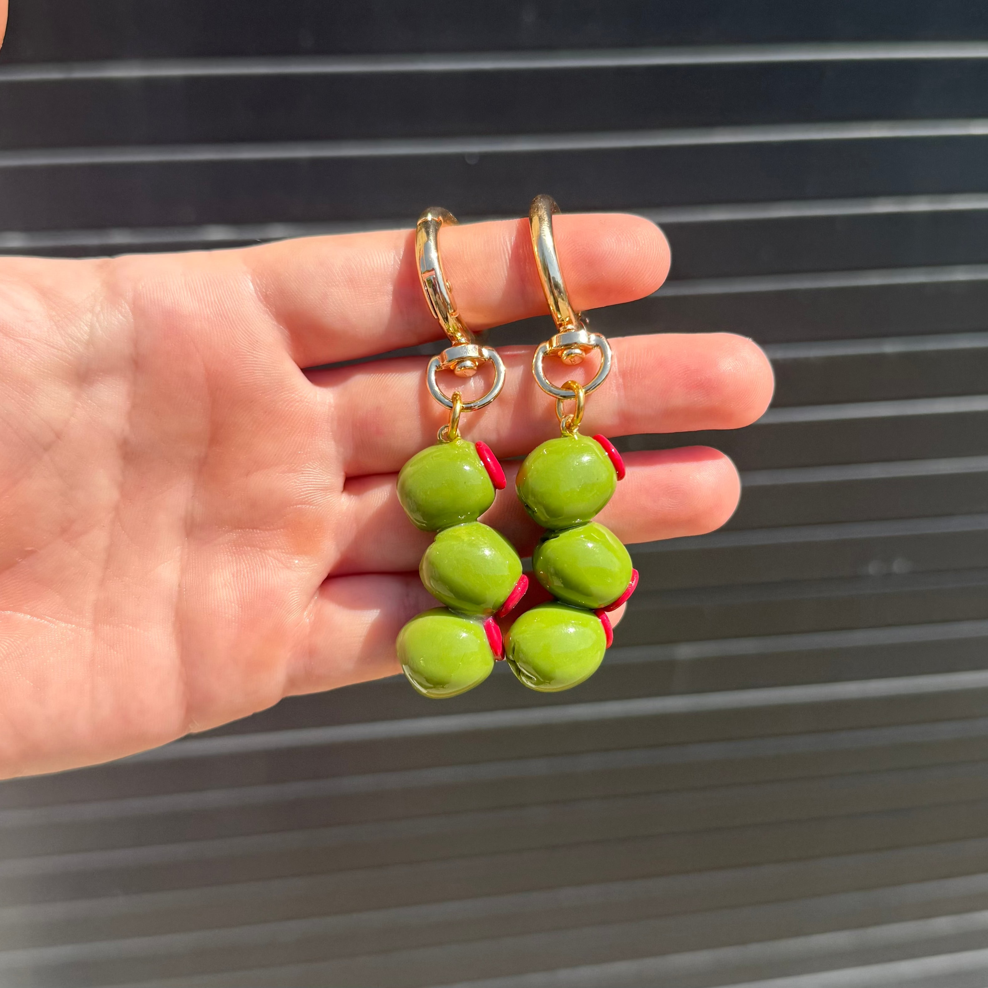 Light green olive keychains hanging in hand. 
