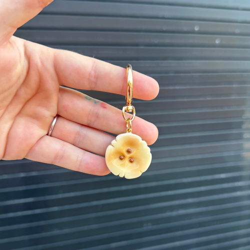 hand holding a keychain with a polymer clay charm shaped like a banana slice. 