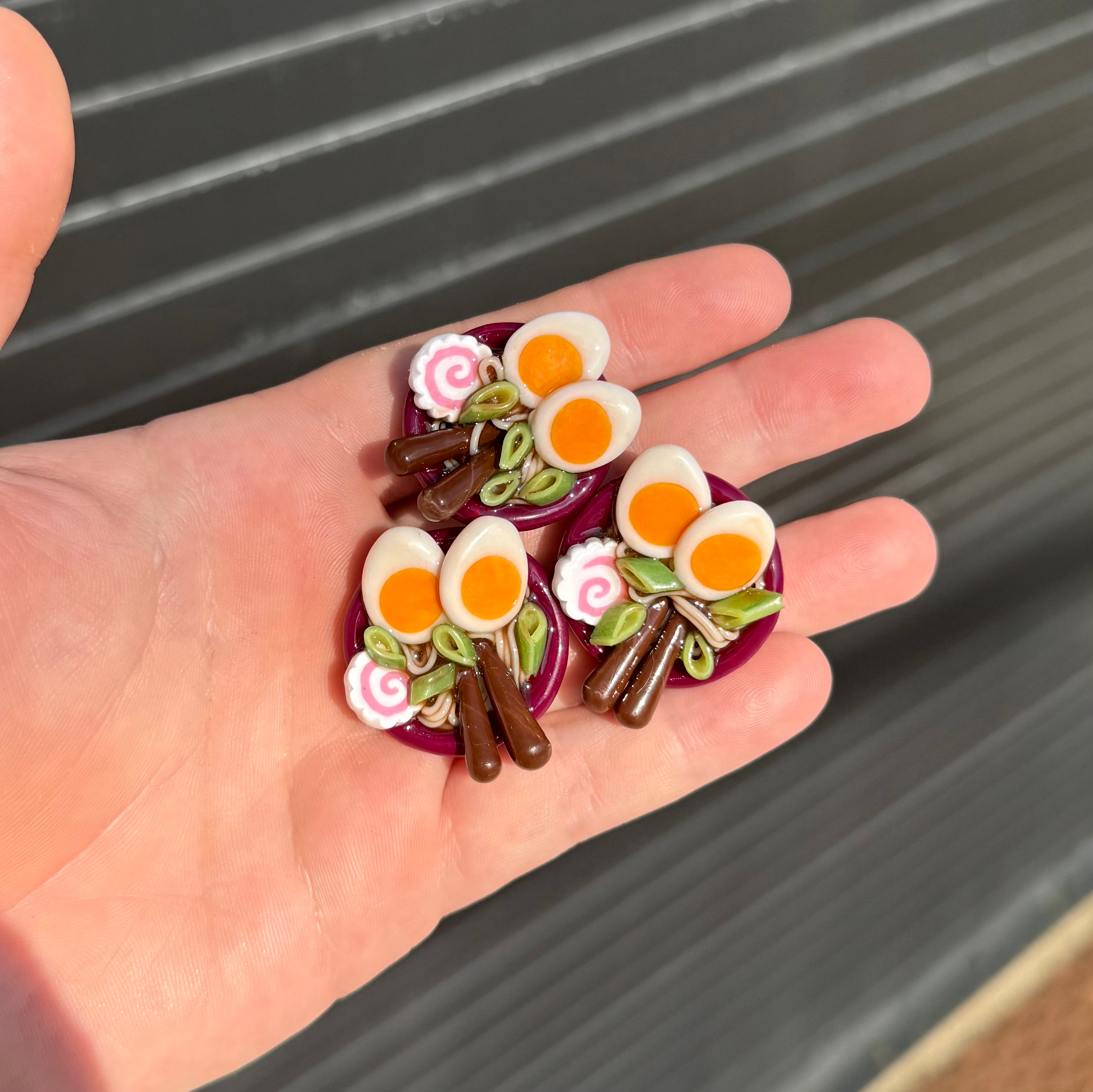 three ramen bowl magnets with soft boiled eggs, green onion, fish chip, and chopsticks 
